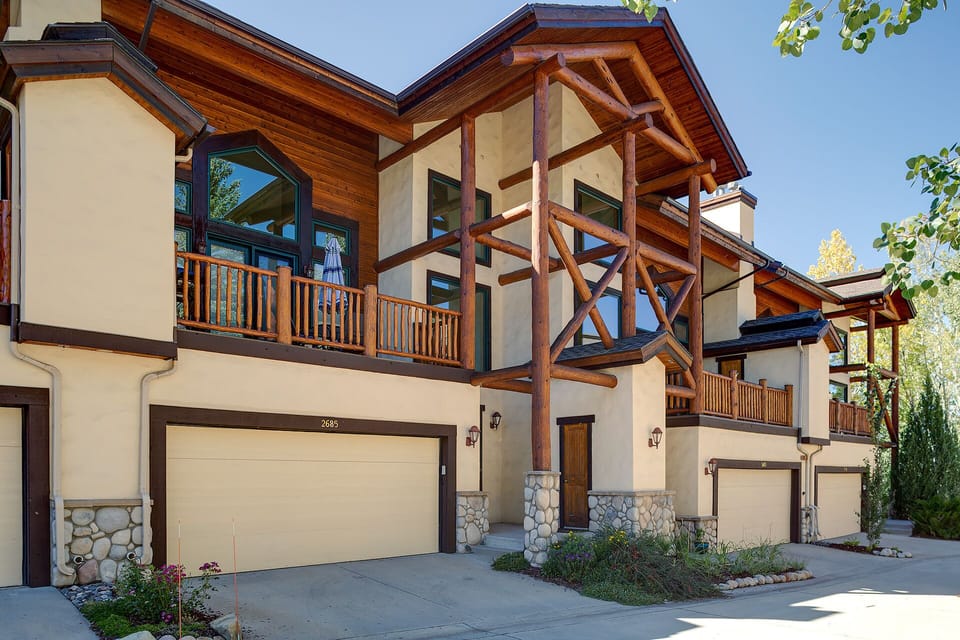 A stunning mountain-style vacation rental featuring timber-frame construction, stone accents, and multiple private balconies in a peaceful residential setting.