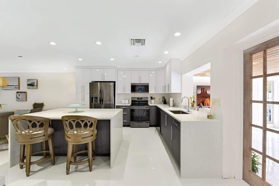 Fully equipped kitchen with breakfast bar seating and modern appliances.