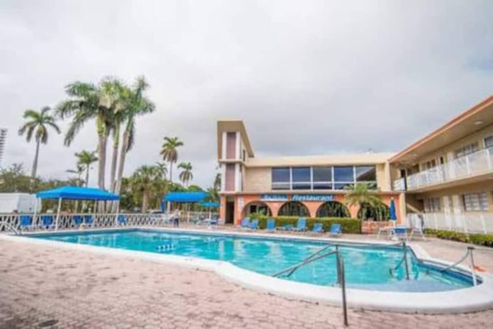Beautiful pool area overlooking the water with lounge chairs in the pool. 
