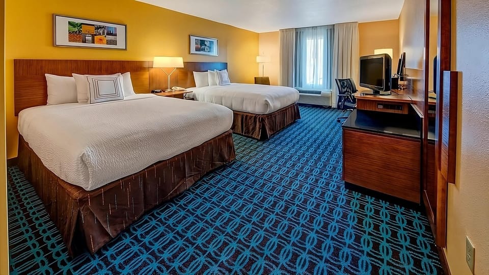 Unwind on plush beds in a bright, spacious room.