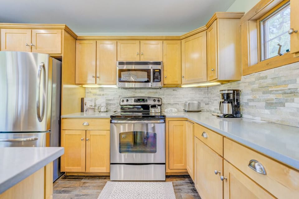 Your fully equipped kitchen features stainless steel appliances and warm wood cabinetry, perfect for preparing memorable meals during your stay.
