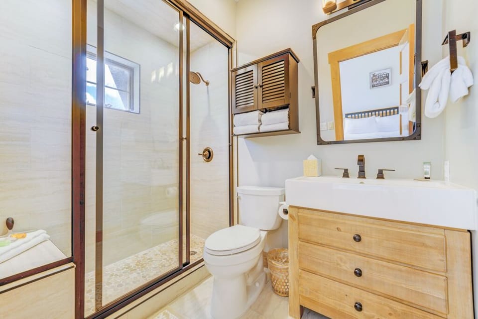 Step into your beautifully appointed bathroom featuring warm wood accents, spacious glass shower, and thoughtful storage—your perfect retreat after a day of adventure.