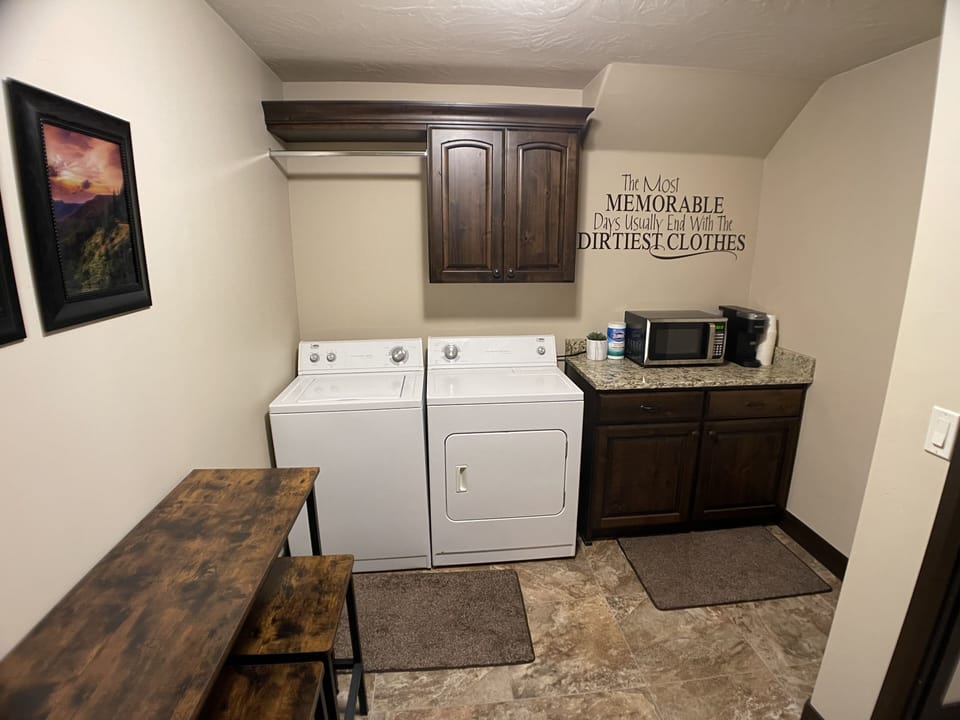 Full-sized washer and dryer in kitchen area with microwave and Keurig machine