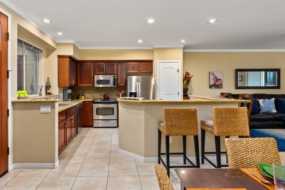Full kitchen with granite countertops, breakfast bar, and stainless steel appliances