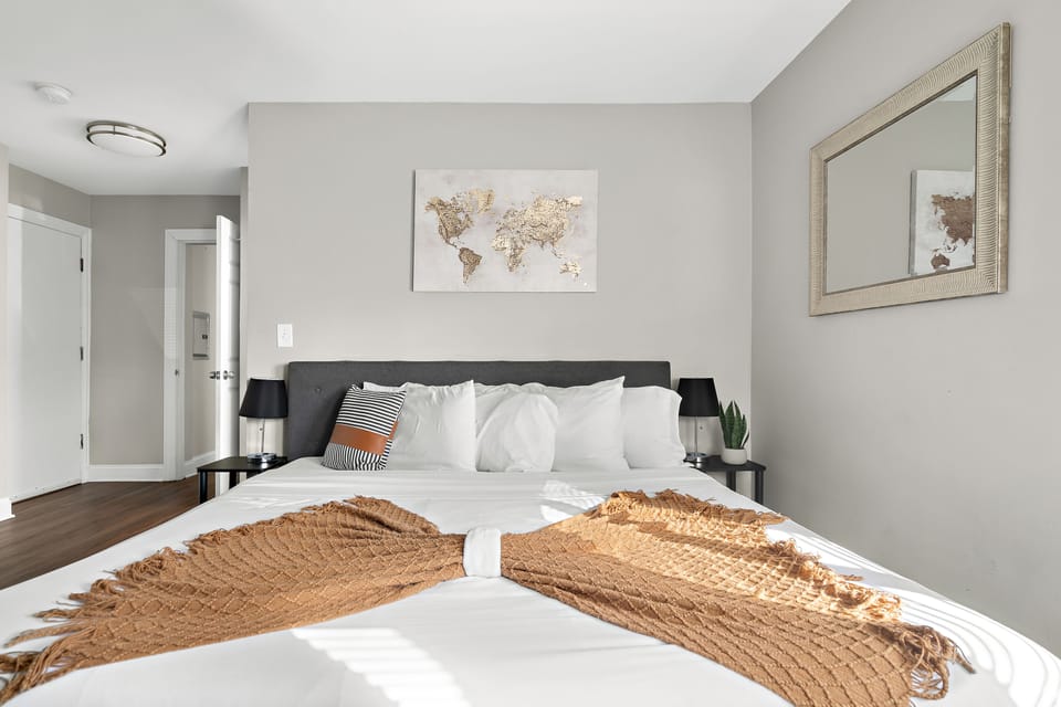 King size bed in master bedroom with soft pillows sheets and comforters. 