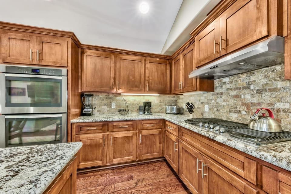 Your gourmet kitchen awaits with granite countertops, premium appliances, and warm wood cabinetry—perfect for creating memorable meals during your stay.