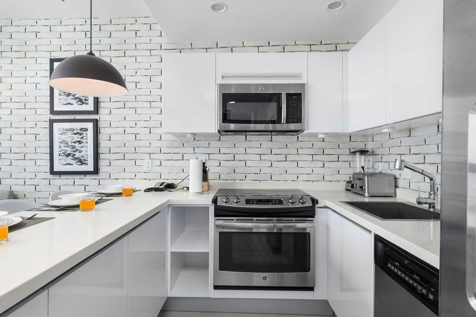Your modern kitchen features sleek white cabinetry, a full-size oven and stove, plus a microwave—perfect for preparing everything from quick snacks to memorable home-cooked meals.