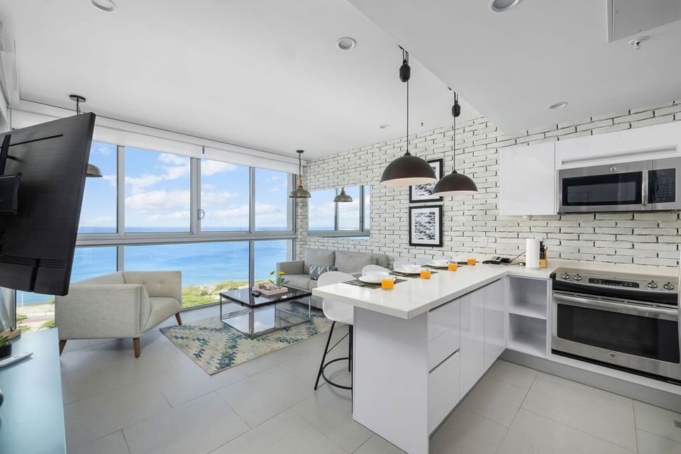 Bright, modern open-concept space where you can cook in your fully equipped kitchen while enjoying stunning sea views. Relax on the cozy living room sofa and soak in the coastal scenery.