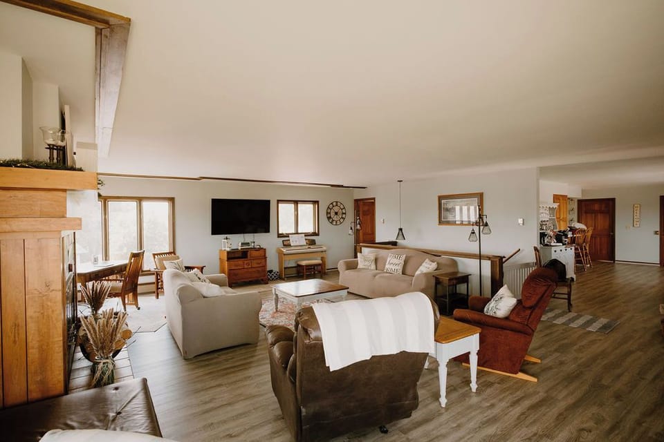 A spacious living room area with ample seating for a large group. 