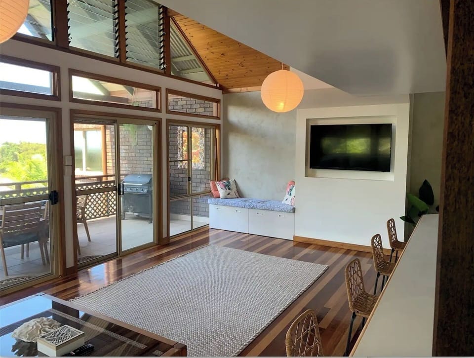 Open plan living space with high ceilings. 55 inch recessed smart TV with Disney + and Netflix