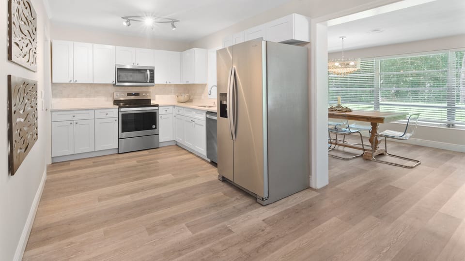 The modern kitchen has dishes, cups, pans, utensils, silverware, and more