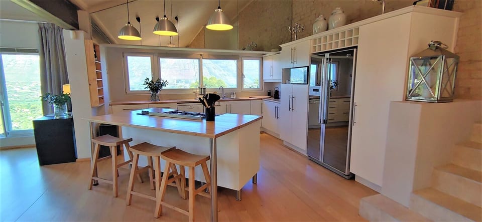 The kitchen is light and airy, with a central island around the gas cooker