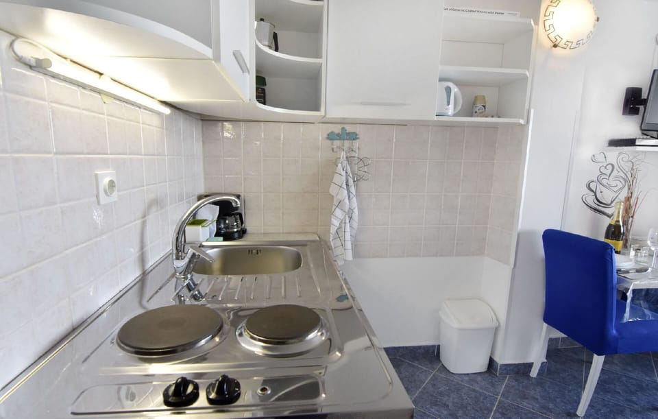 The kitchen with electric oven with two hotplates, refrigerator, coffee machine and mocha.