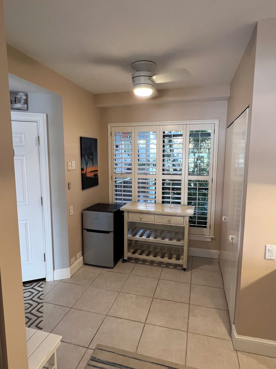 Open space with laundry, table to fold clothes, fridge for drinks.