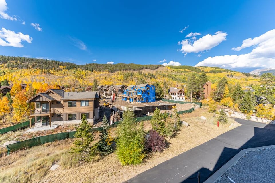 Mountain community surrounded by golden aspen forests and alpine peaks under brilliant blue skies.