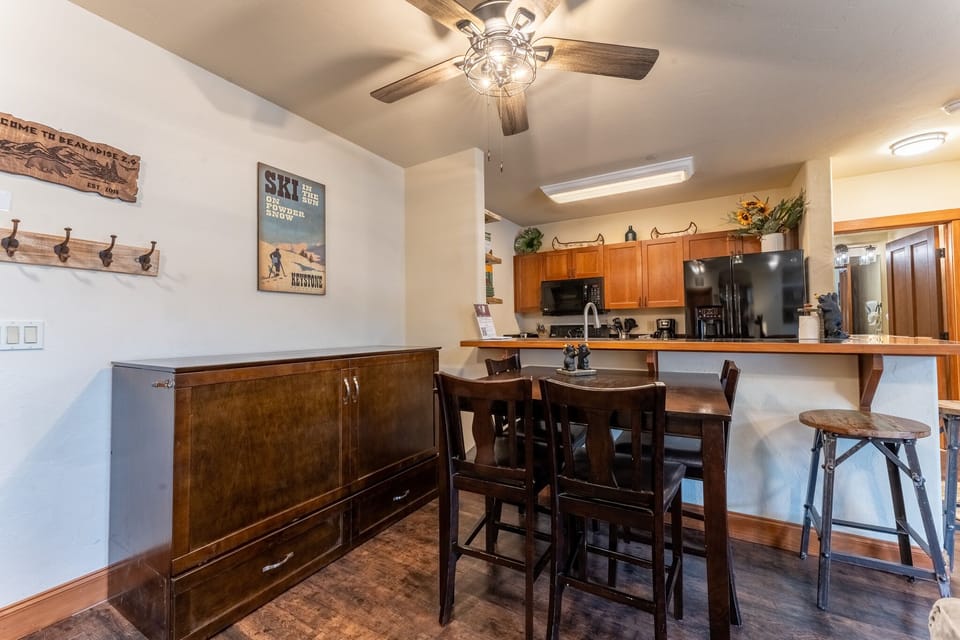 Your open kitchen and dining area features warm wood cabinets, modern appliances, and cozy seating for memorable meals together.