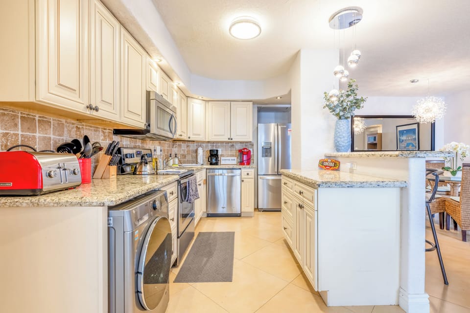 Kitchen with granite counters, stainless steel appliances and in-unit laundry.