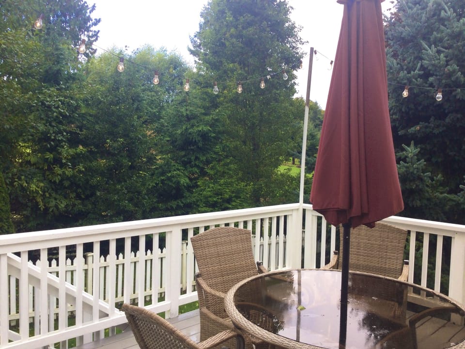 Carriage house back deck with stairs down to fenced yard.