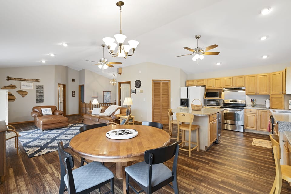 Kitchen table, living room on left, refrigerator, island, microwave, range/oven