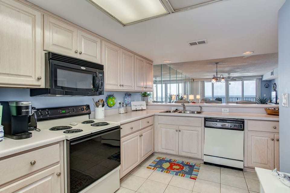 Fully equipped kitchen with white cabinets at Wind Drift Orange Beach vacation rental