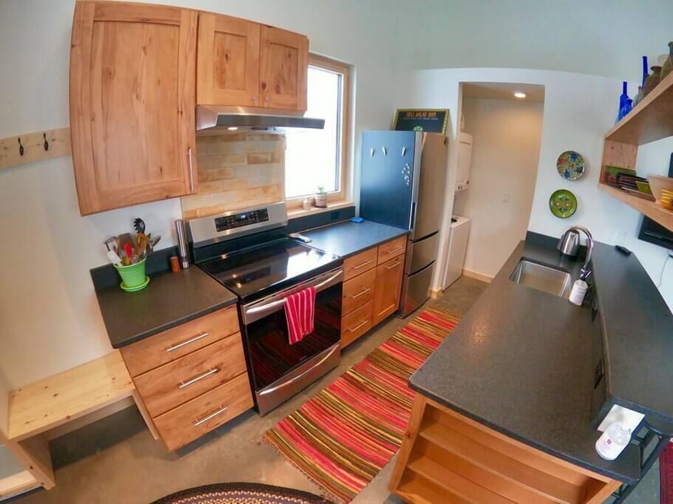 The kitchen features new appliances including an induction range, range hood, dishwasher, fridge, electric teapot, coffee maker, blender, microwave, toaster oven and more. 