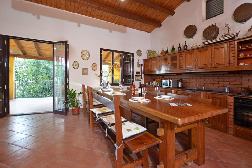 The wide kitchen with the dinner table, open on both side of the Villa