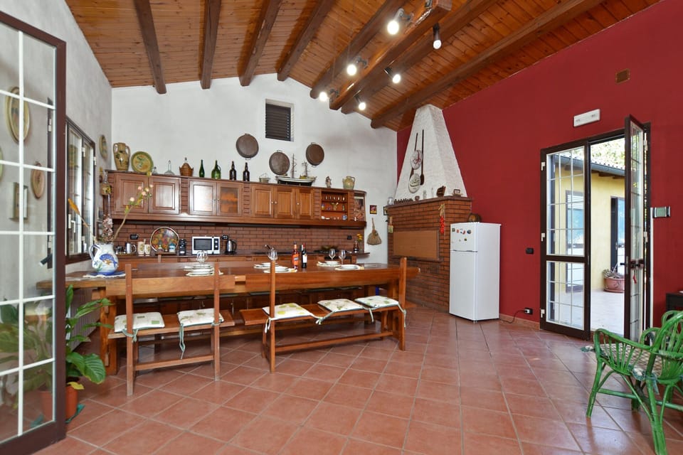 The wide kitchen with the dinner table, open on both side of the Villa