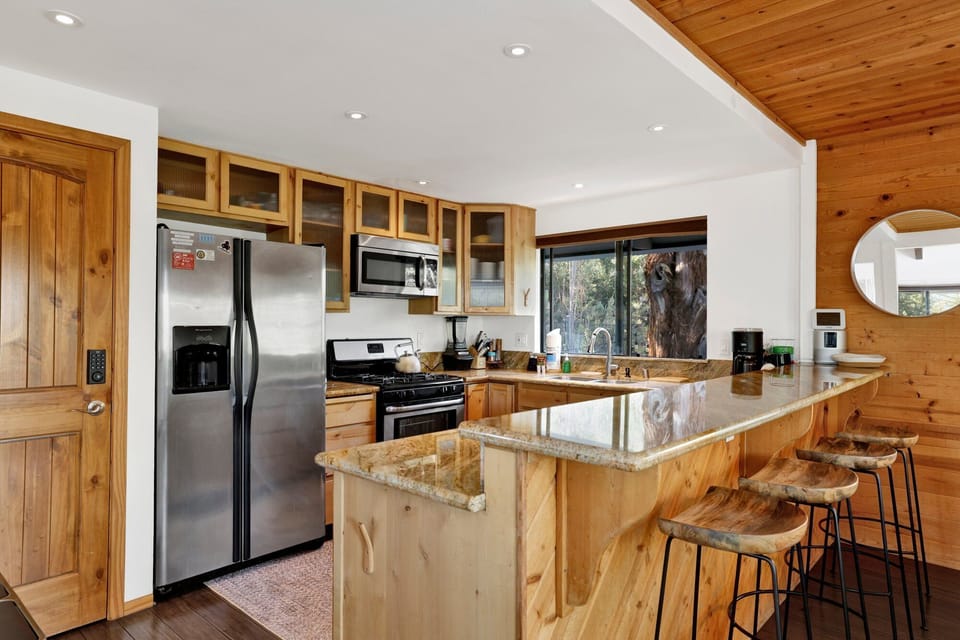 Fully equipped cabin kitchen with ample cabinetry, stove, fridge, microwave, and coffee maker—perfect for cooking meals, morning coffee, and feeling right at home on your stay.
