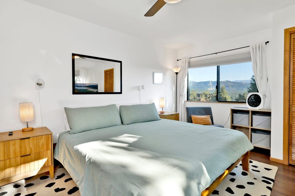 Peaceful cabin bedroom with plush bedding, and beautiful views—ideal for restful nights, cozy mornings, and a relaxing mountain escape.