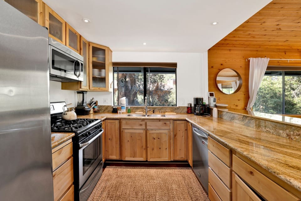Fully equipped cabin kitchen with ample cabinetry, stove, fridge, microwave, and coffee maker—perfect for cooking meals, morning coffee, and feeling right at home on your stay.