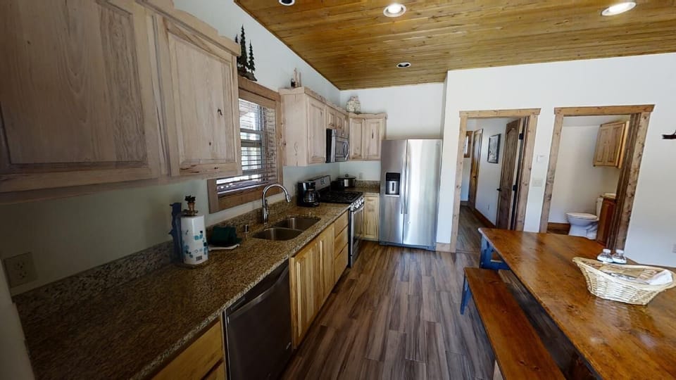 Picture yourself cooking a favorite meal in this warm, wood-finished kitchen with its spacious granite counters, modern appliances, and inviting open layout that flows into your cozy living area.