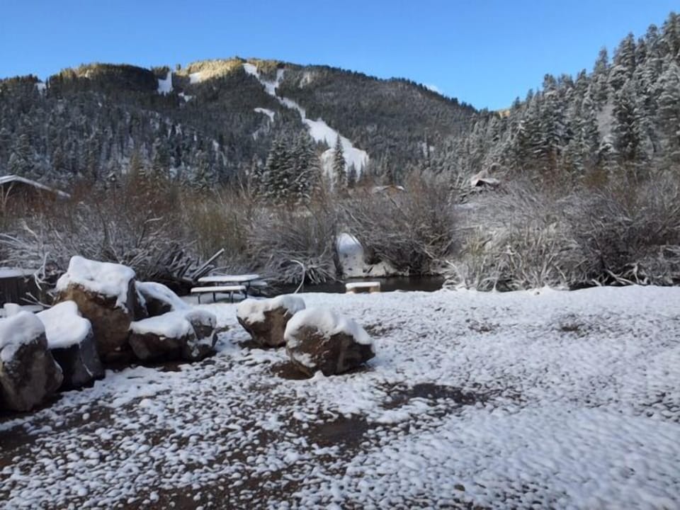 A serene winter landscape surrounds the property, with snow-dusted evergreens and peaceful mountain views creating a picturesque seasonal backdrop for the vacation rental.