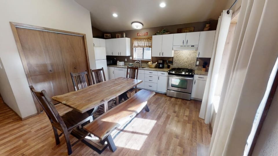 Gather around the farmhouse-style dining table in your fully equipped kitchen, where natural light streams in and everything you need to cook a delicious meal is right at your fingertips.