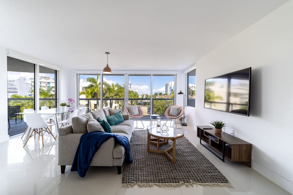 Spacious modern living room with Smart TV, dining area, and balcony at Bay Harbor Islands vacation rental near Miami Beach and Bal Harbour Shops