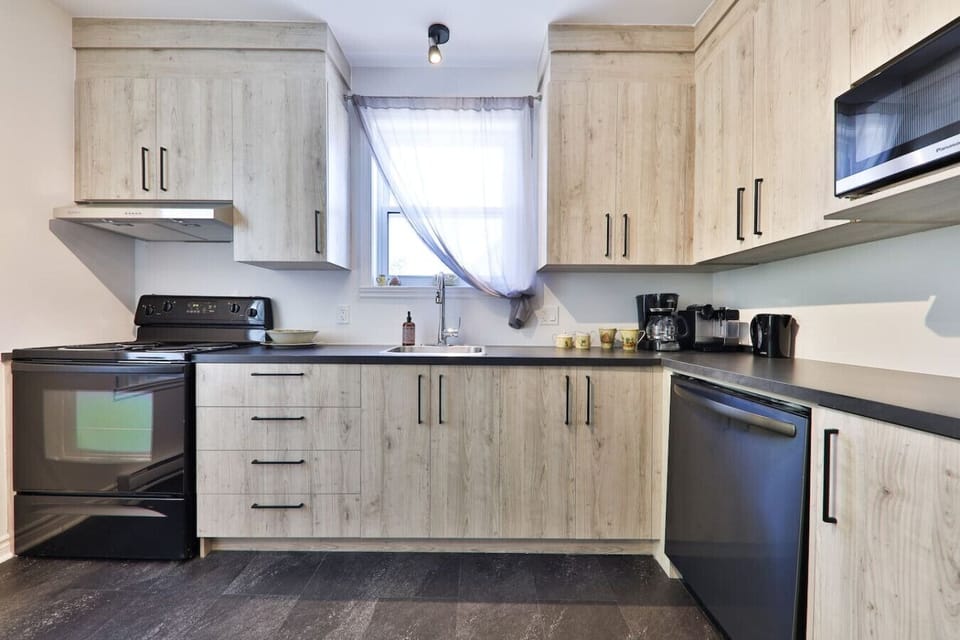 Modern kitchen with stove, dishwasher, microwave, and coffee maker (percolator or Nespresso)