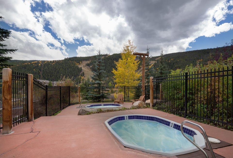 Soak in the hot tub while taking in stunning mountain views surrounded by golden autumn foliage and forest-covered peaks.