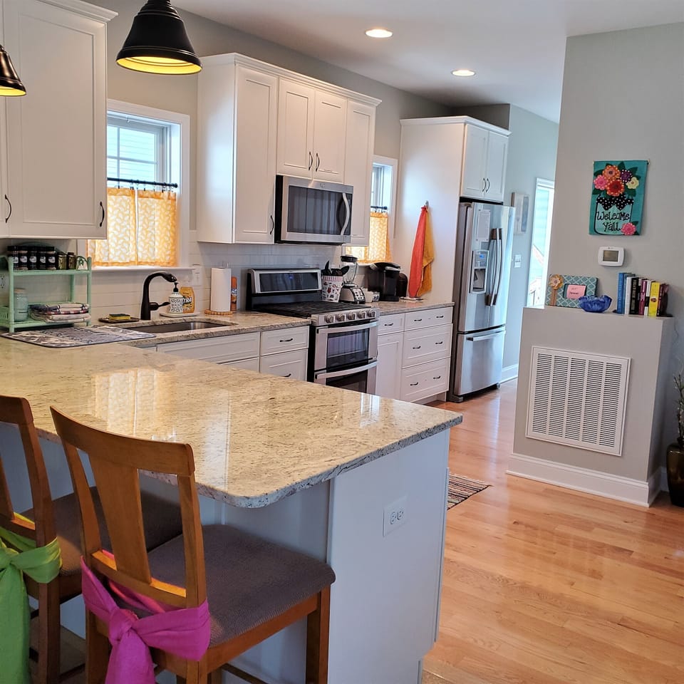The kitchen features a gas range and double oven. Stainless appliances & granite