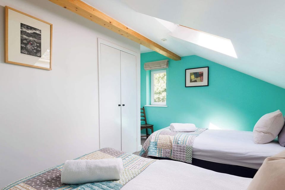 Light and bright twin room, with pops of colour and exposed beams.