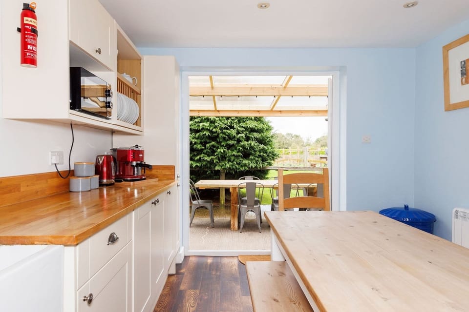 The bright and cheerful kitchen opens onto the garden, bringing the beauty of nature inside.
