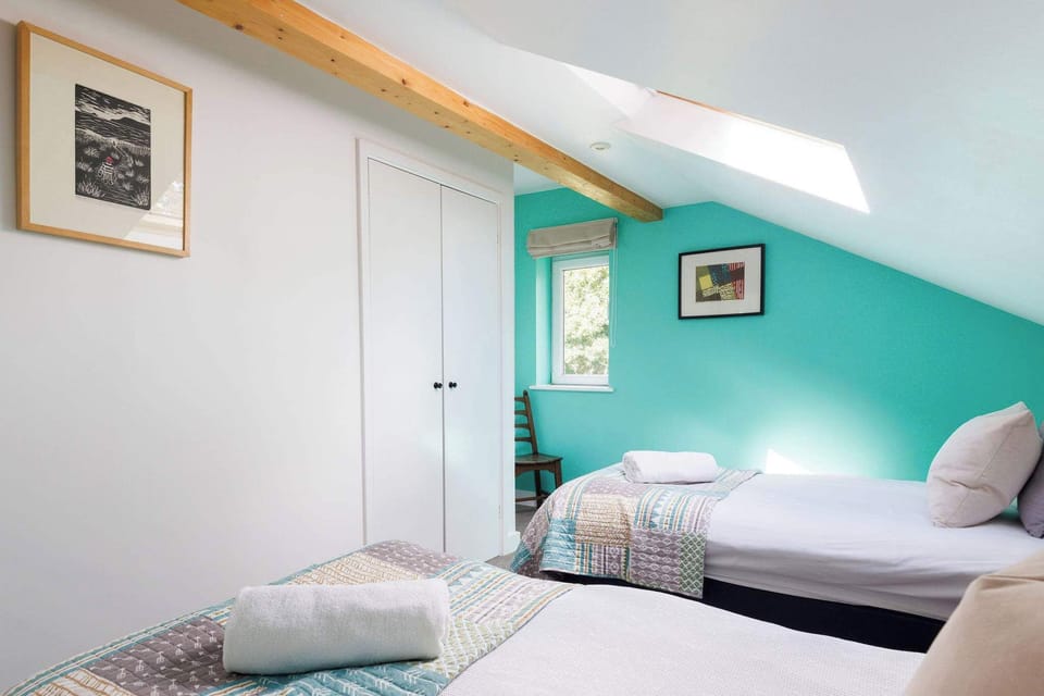 Light and bright twin room, with pops of colour and exposed beams.