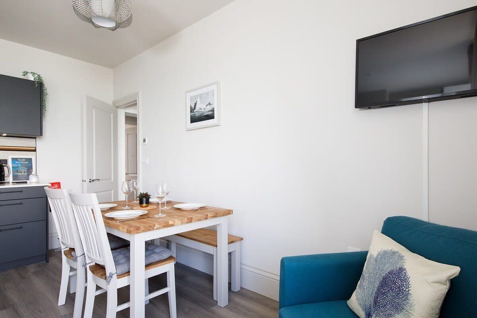 The open plan living area features a table for 4 and a Smart TV