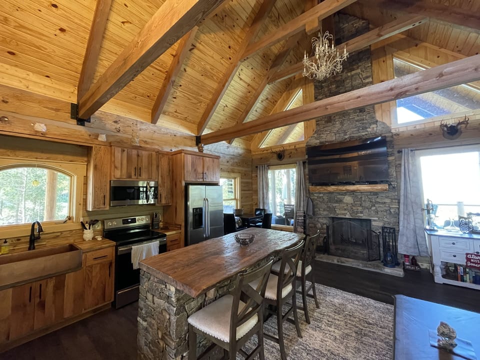 Living area floor to ceiling stone wood burning Fireplace.