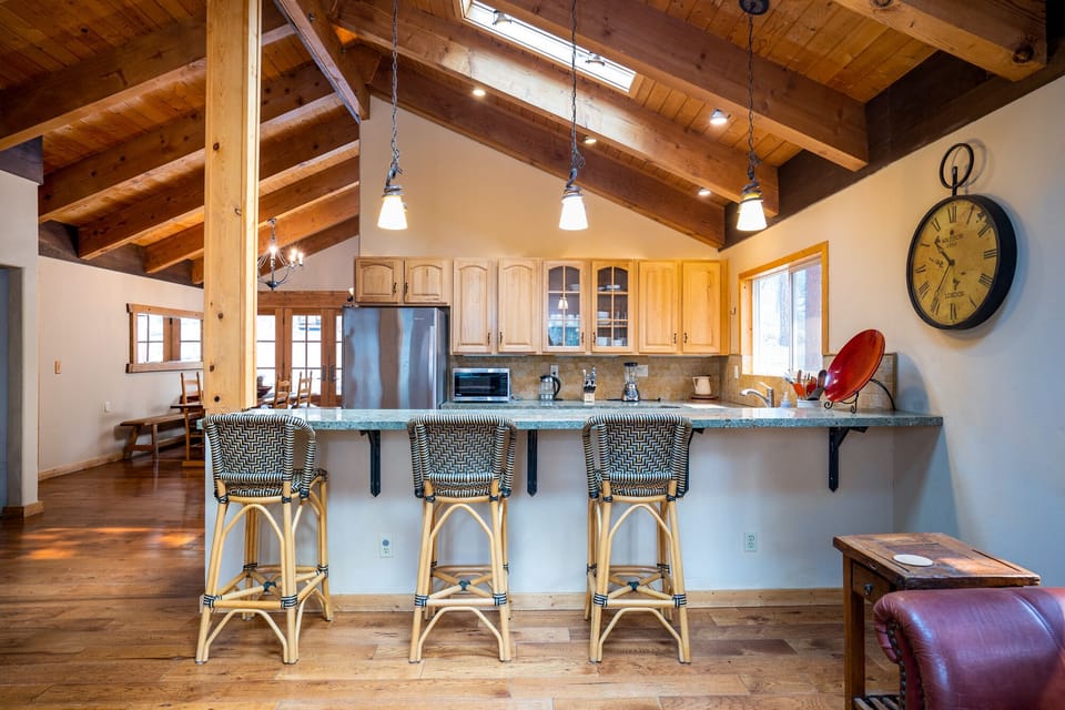 The spacious living room and kitchen are seamlessly connected, offering a bar seating area that's perfect for mixing drinks or casual meals