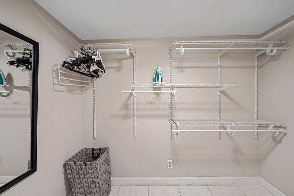 Spacious walk-in closet with adjustable shelving, ample hanging space, and storage baskets—perfect for keeping your belongings organized and your stay clutter-free.