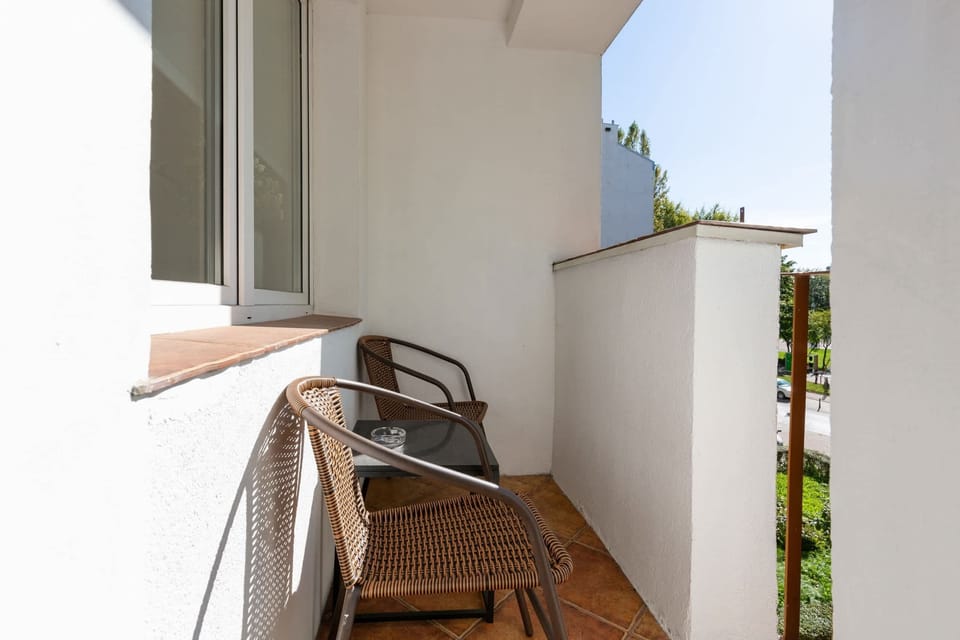A cozy balcony with a small table and chairs, perfect for enjoying a cup of coffee outdoors.





