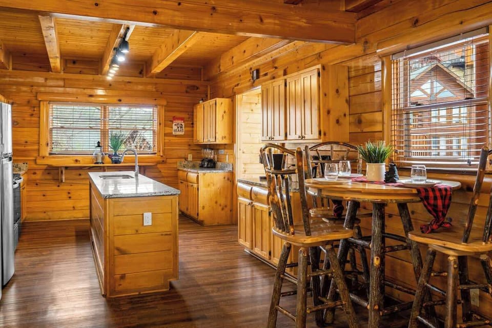 There is a high top table next to the kitchen with seating for three people.