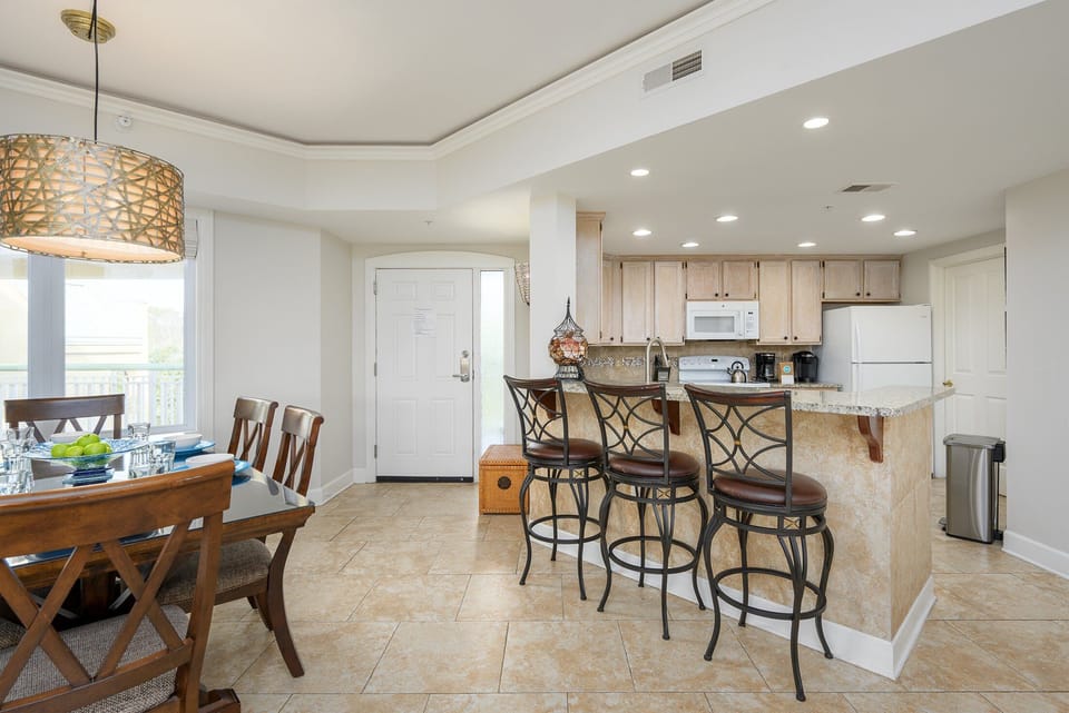 The generous island and breakfast bar offer comfortable seating for casual meals. Clean sightlines make this kitchen ideal for both everyday living and entertaining.