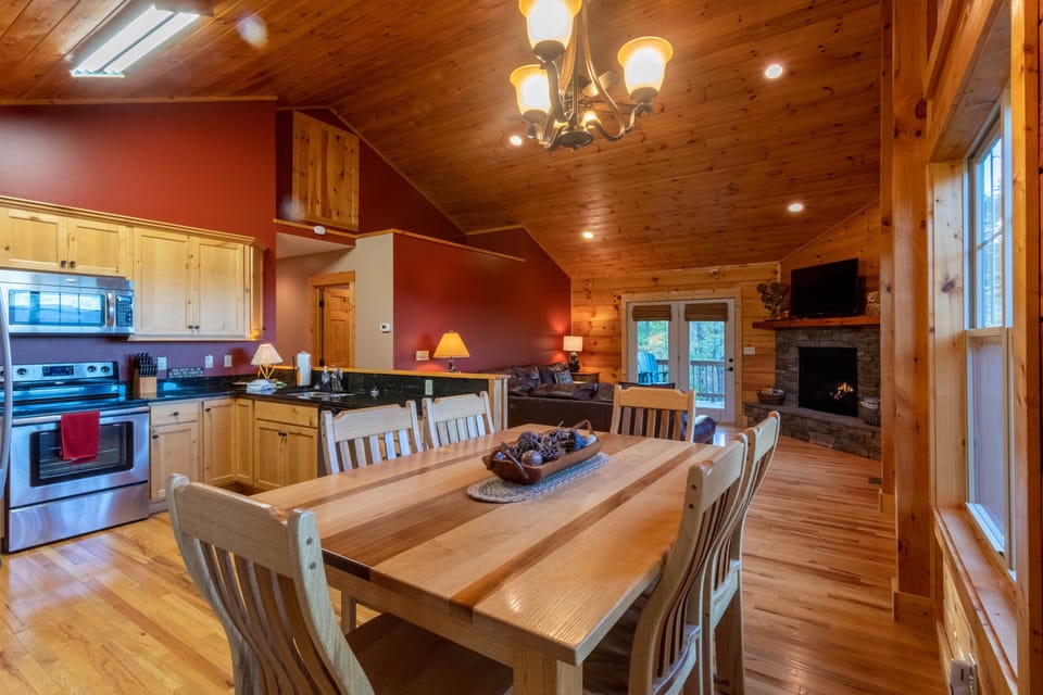 Gather around the big wooden table with the kitchen steps away and a glowing stone fireplace just beyond. Room for everyone at Firefly Cabin.