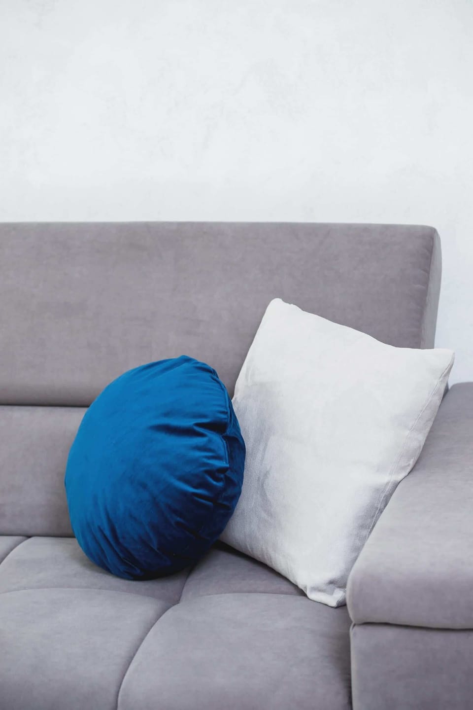 A close-up of a decorative blue cushion on the sofa, adding warmth to the space.
