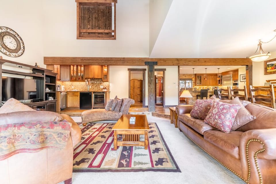 Sink into plush leather sofas in your warm mountain retreat, where rustic wood beams and a cozy living space create the perfect alpine getaway.